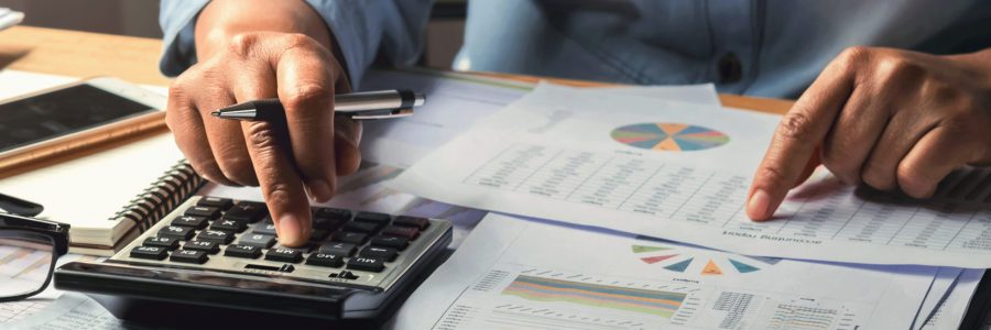 accounting concept. businesswoman working using calculator with money stack in office