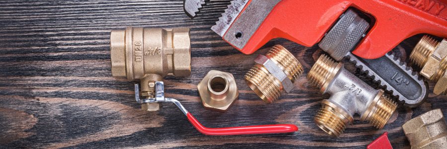 Collection of plumbers equipment on wooden board plumbing concept.