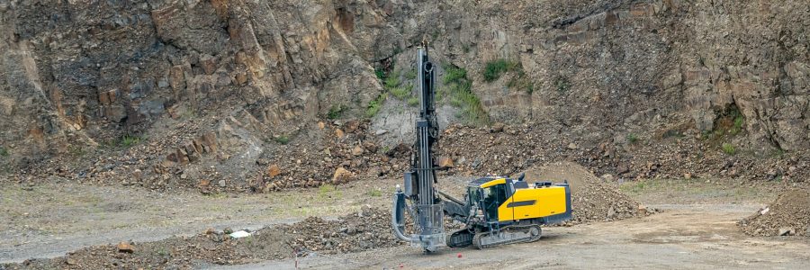 Opencast mining quarry with mining drilling machine. Mining in the granite quarry. Mining industry.